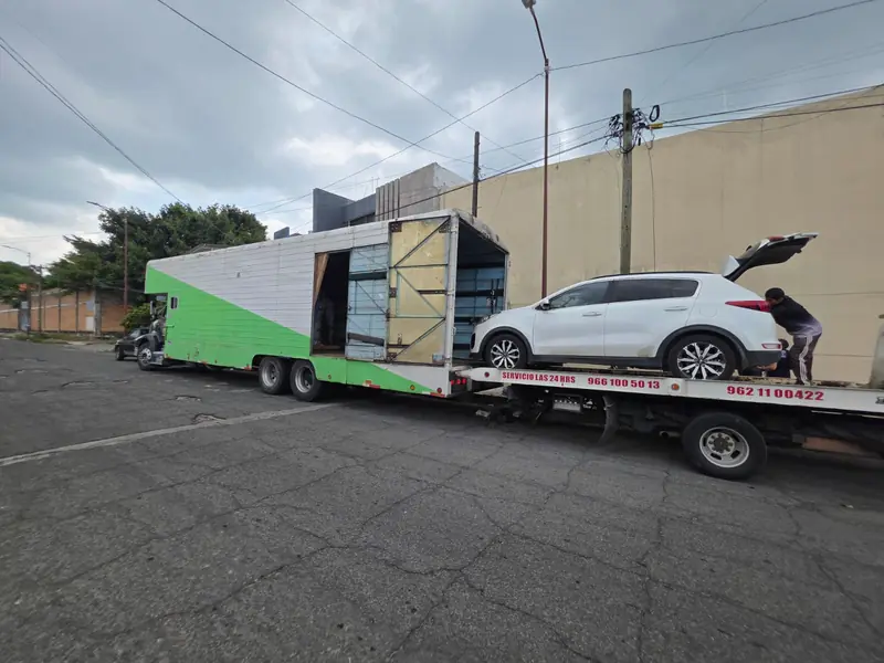 Camión de Express Rico junto a una grúa con una camioneta blanca